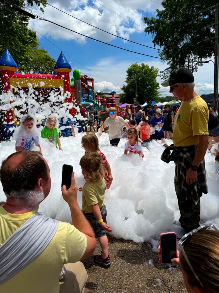 Families enjoying a foam party at a community event